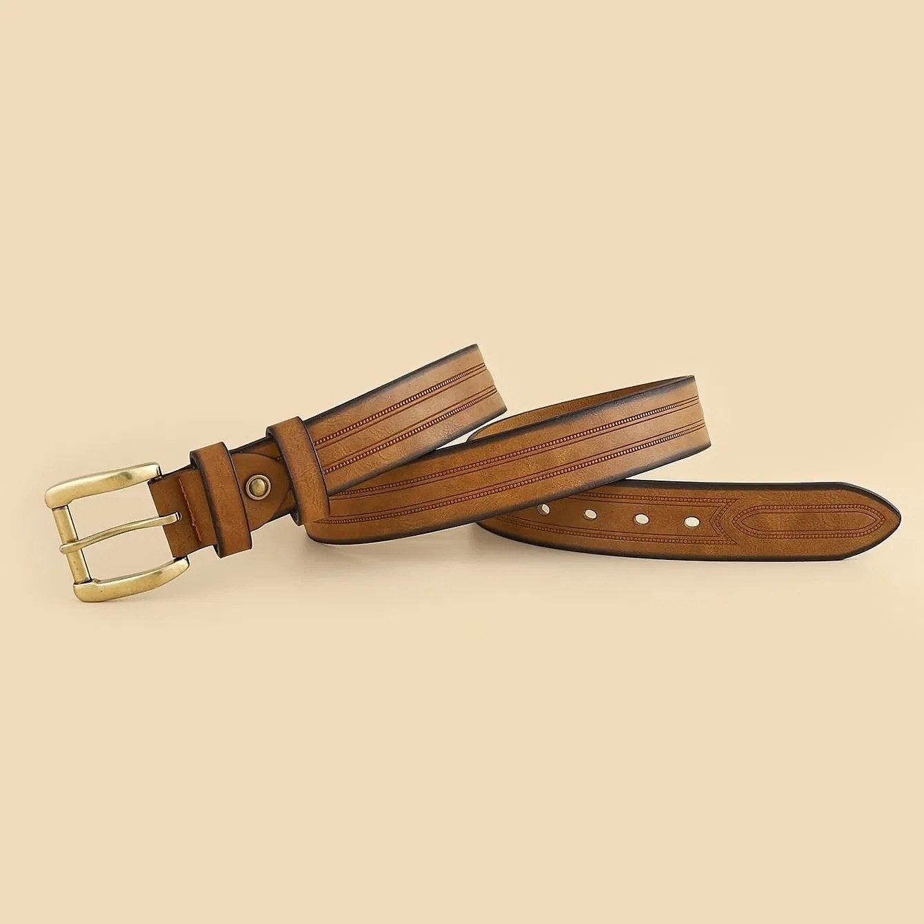 Full length of the brown and tan tooled Western belt in an S-curve, showing the strap and brass roller buckle